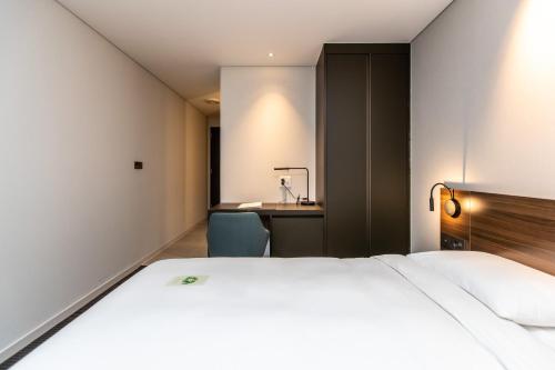 a hotel room with a bed and a desk at Grab The Ocean Songdo in Busan