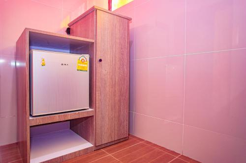 a bathroom with a mirror in a wooden cabinet at Thansila Resort&Garden Buriram in Buriram