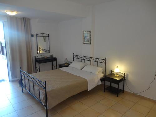 a bedroom with a bed and two night tables at Polydoros Appartments in Agios Nikolaos