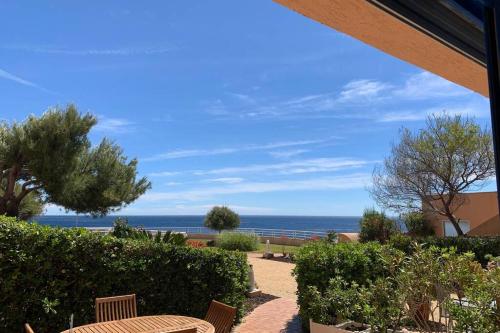 a patio with a table and a view of the ocean at Cap Neree Petit coin de paradis pieds dans l eau in Saint-Raphaël