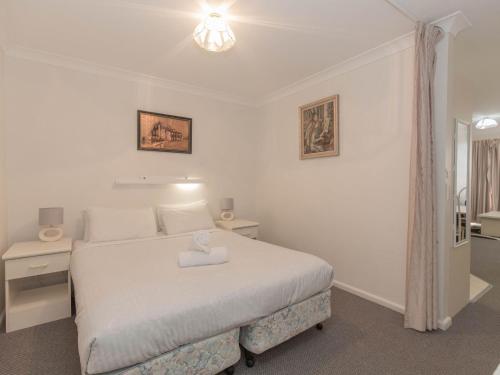 Un dormitorio con una cama blanca con una toalla encima. en Horizons 213/10 Kosciuszko Road, en Jindabyne