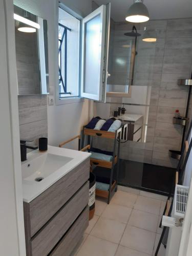 La petite salle de bains est pourvue d'un lavabo et d'un miroir. dans l'établissement Appartement rénové Le New-York en centre ville - Terrasse et parking -, à La Roche-Chalais