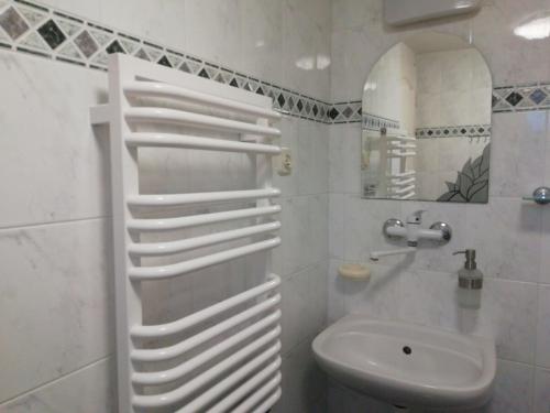 a white bathroom with a toilet and a sink at Pokoje przy fontannie in Karwia