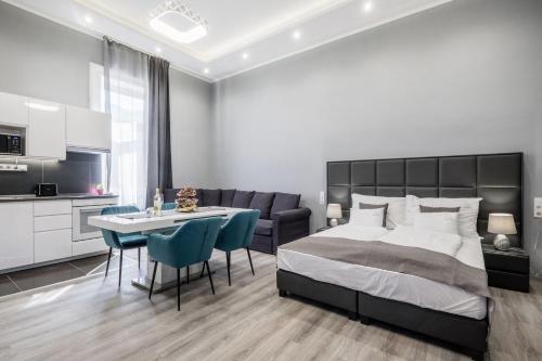a bedroom with a bed and a table and chairs at Prime star Deak ter Modern Luxury Apartments Budapest in Budapest
