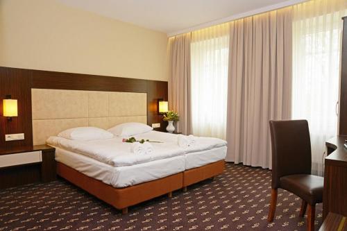 a hotel room with a large bed and a desk at Hotel Fryderyk in Nysa