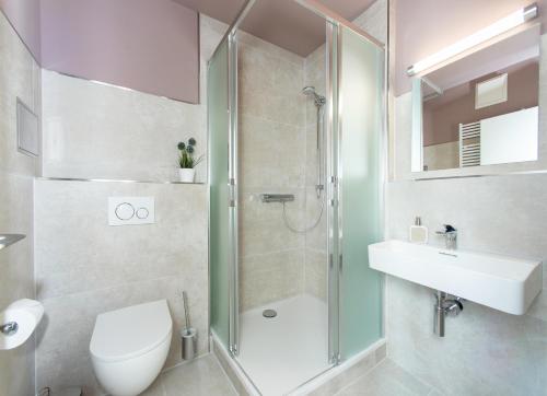 a bathroom with a shower and a toilet and a sink at Appartementhaus Zum Strandkorb in Kühlungsborn