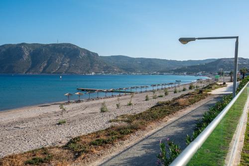 a beach with a street light next to the water at Royal Bay Suites in Kefalos