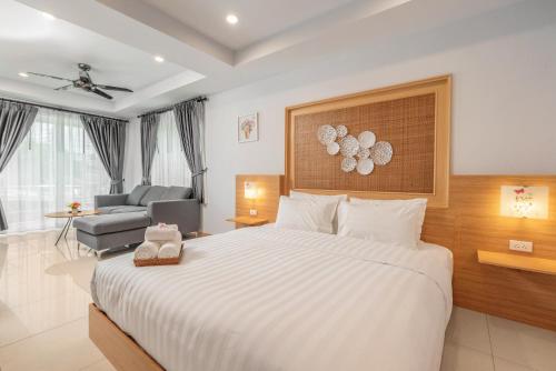 a hotel room with a large bed and a chair at Gala Pavilion Villa in Pattaya South