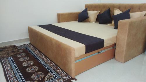 a bed with blue pillows and a rug in a room at Krishnabalram wellness & Ayurveda centre in Rishīkesh