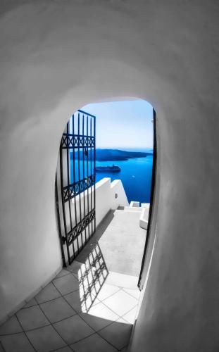 a door to a balcony with a view of the ocean at Panorama Suites in Fira