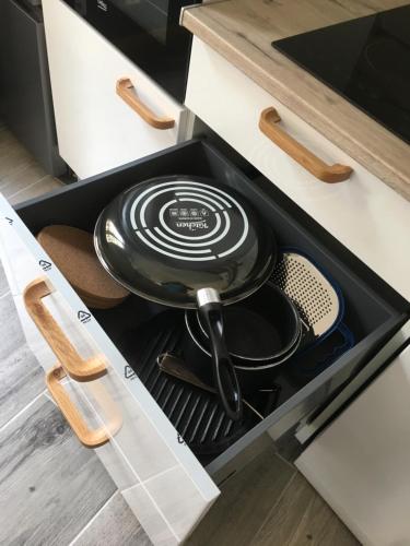 une casserole et des poêles dans un tiroir dans une cuisine dans l'établissement LA CASA DES PETITES MARIES terrasse clim wifi, à Marseille