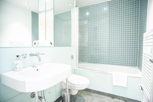a white bathroom with a sink and a toilet at One Bed Serviced Apt in Farringdon in London