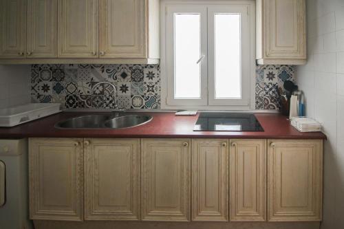 eine Küchentheke mit einem Waschbecken und einem Fenster in der Unterkunft Pueblo Andaluz 670 in Torrox Costa
