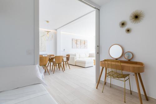 a white living room with a mirror and a table at MEVAMAR in Fornells