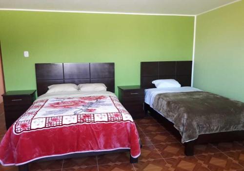 a bedroom with two beds and green walls at La Azotea in Huancayo