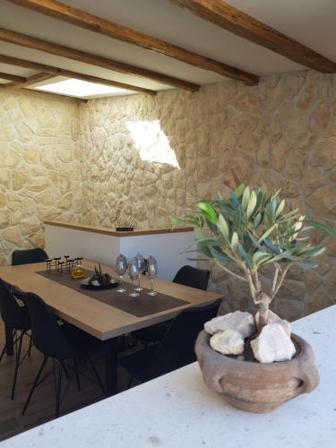 a dining room with a table and a stone wall at NEW VILLA IN OLD CENTER - Pag in Pag
