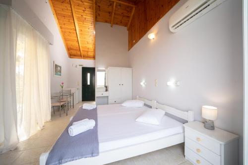 a white bedroom with a bed and a table at Xi Village in Xi