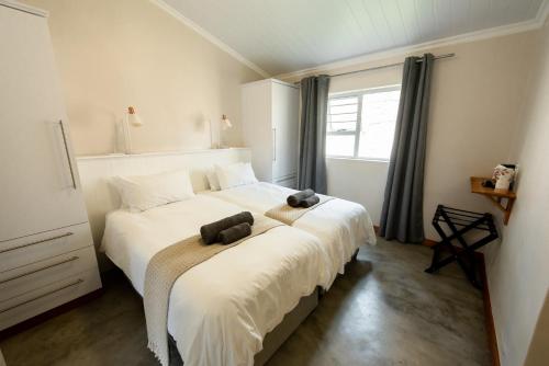 a bedroom with a large bed with two stuffed animals on it at Treyntjes Rivier Cottages in Caledon