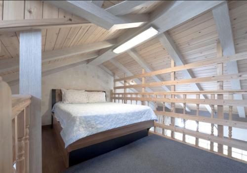 a bedroom with a bed in a room with wooden ceilings at Jeju Time-Travel Pension in Jeju