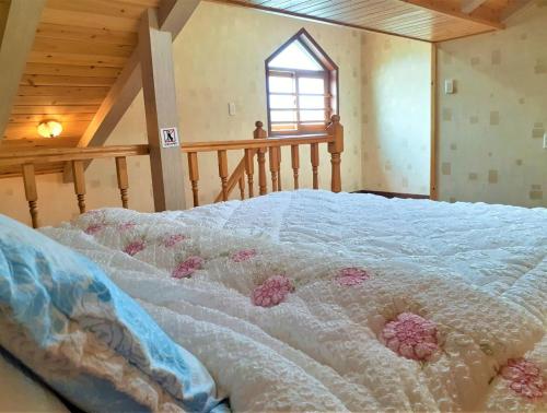 a bed in a room with flowers on it at Jeju Time-Travel Pension in Jeju