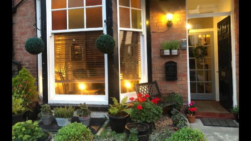 a house with a bunch of potted plants on the porch at North Sands Lodge in Scarborough