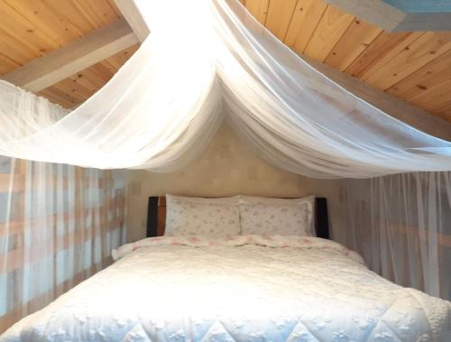a bedroom with a bed with a white canopy at Jeju Time-Travel Pension in Jeju
