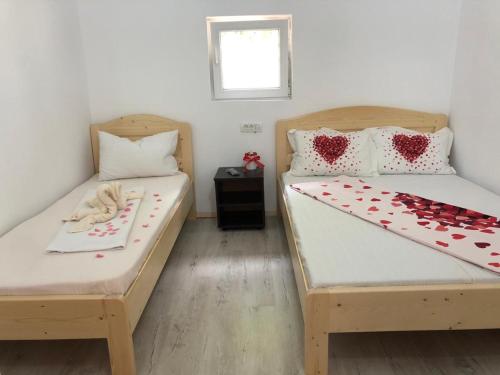 two beds in a room with hearts on them at Cabana Elyana Mraconia in Eşelniţa