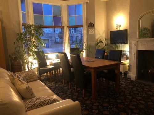 a living room with a table and chairs and a couch at North Sands Lodge in Scarborough