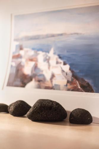 three rocks on a table in front of a painting at Villa Anemeli in Vóthon