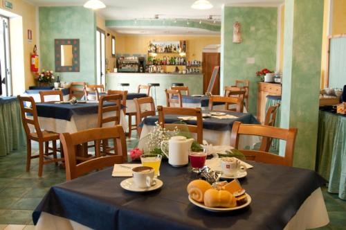 a restaurant with tables and chairs with food on them at Abbaidda Hotel in Valledoria