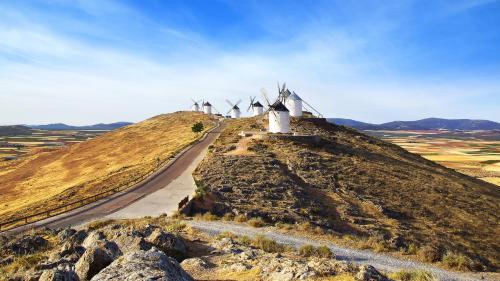 a row of windmills on a hill with a road at Apartamento Vistas molineras in Consuegra