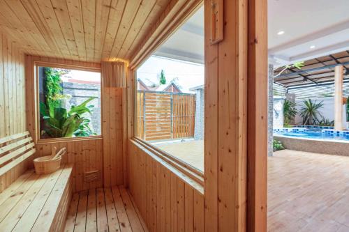 a wooden room with a large window and a swimming pool at Gala Pavilion Villa in Pattaya South