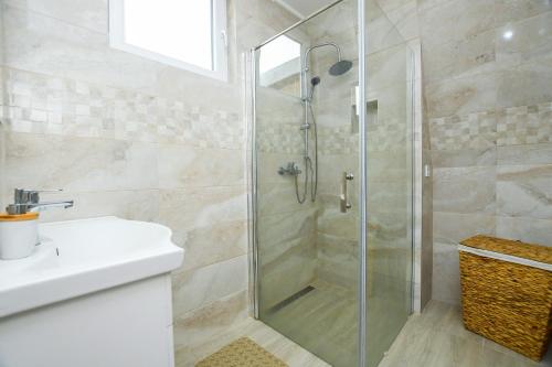 ein Bad mit einer Glasdusche und einem Waschbecken in der Unterkunft Apartmani Pakalovic in Davidovac