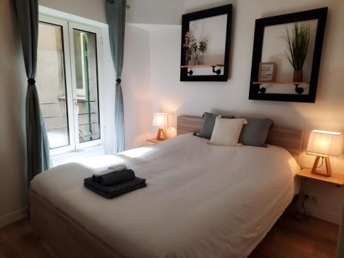 una camera con un letto bianco con due lampade e una finestra di Beautiful Old Town flat, near the beach a Nizza