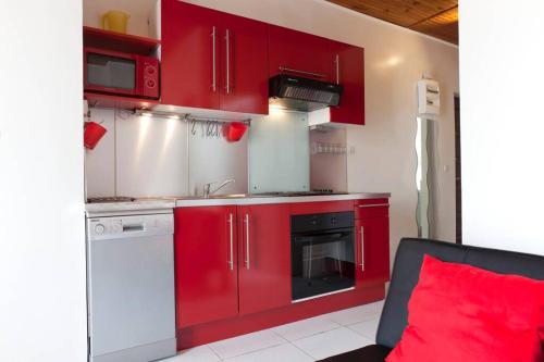 - une cuisine avec des placards rouges et un oreiller rouge dans l'établissement #PalavasLesFlots #2bedrooms #AirConditioned #100MetersFromTheBeach, à Palavas-les-Flots