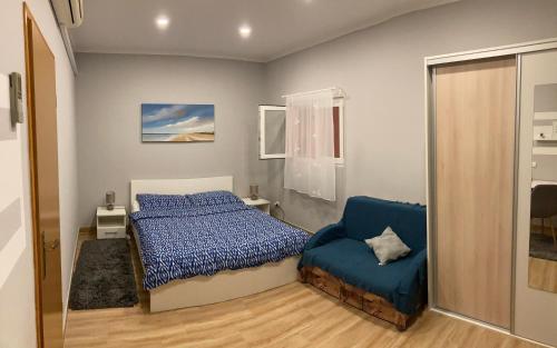 sypialnia z łóżkiem i niebieskim krzesłem w obiekcie Apartman Turanj w mieście Turanj