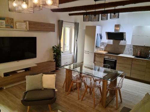 un salon avec une table en verre et des chaises dans l'établissement Beautiful Old Town flat, near the beach, à Nice