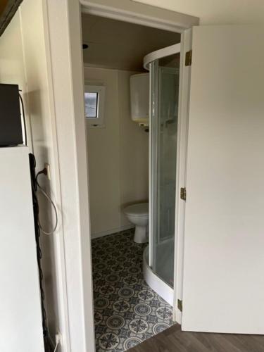 a bathroom with a glass shower and a toilet at Camping Thalassa Belgische Kust Chalet in Bredene