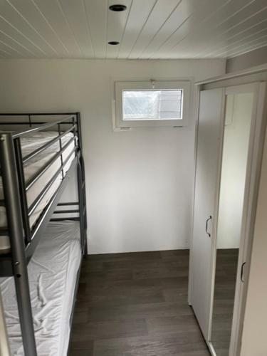 Zimmer mit Etagenbett und Fenster in der Unterkunft Camping Thalassa Belgische Kust Chalet in Bredene