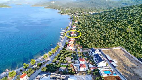 een eiland met een gele cirkel naast het water bij Apartments Stipo in Drače