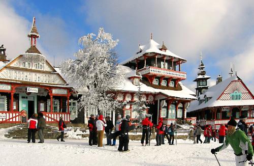 a group of people standing in the snow in front of a building at Penzion Silverado in Horní Bečva