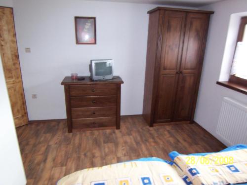 a bedroom with a wooden dresser with a tv on it at Penzion Silverado in Horní Bečva