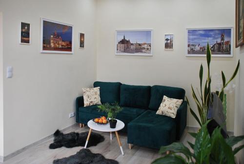 sala de estar con sofá verde y mesa en Apartament - Przy Rynku en Tarnowskie Góry