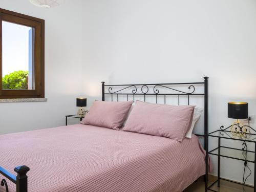 a bedroom with a bed with pink sheets and a mirror at Myrsine 7D - Klodge in Murta Maria