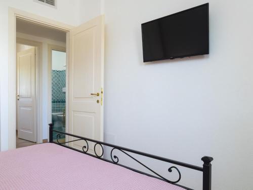 a bedroom with a bed and a flat screen tv on a wall at Myrsine 7D - Klodge in Murta Maria