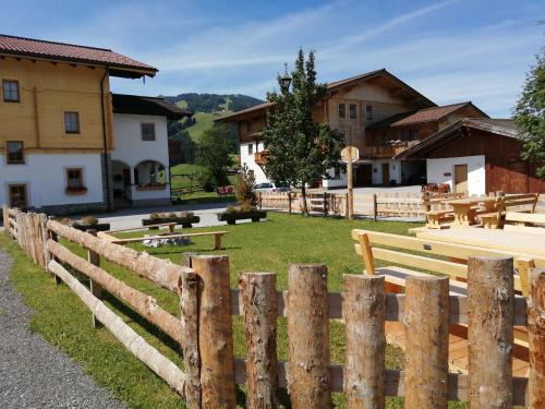 a wooden fence in front of a yard with buildings at Landhaus Fingerhof in Flachau