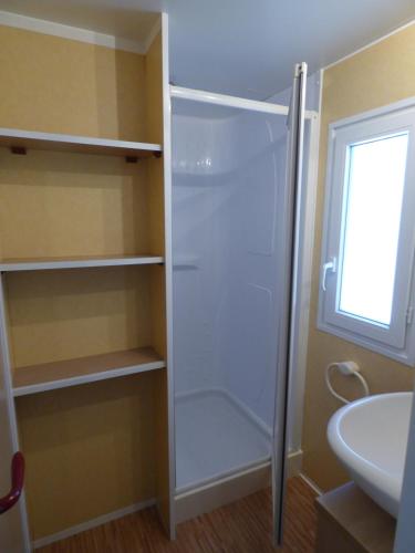 a bathroom with a walk in shower next to a sink at Camping Barraquetes in Sueca