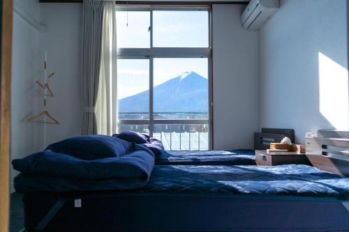 Fuji Guest House Ao في فوجيكاواجوتشيكو: سريرين في غرفة نوم مطلة على جبل