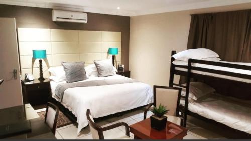 a bedroom with two bunk beds and a table at Lakeview Boutique Hotel & Conference Center in Benoni
