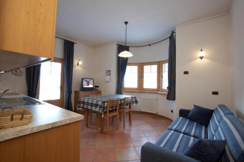 a kitchen and living room with a table and a couch at Appartamenti Lea Pontiglia in Livigno